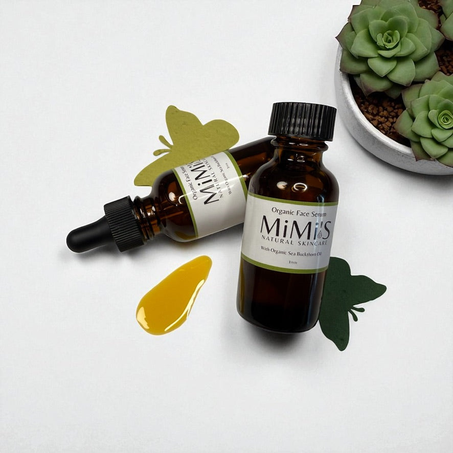 Two bottles of Mimi's Organic Extracts on a white background with green leaves and a plant.