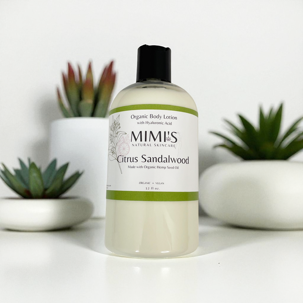 Bottle of Mimis Citrus Sandalwood organic body lotion with plants in the background