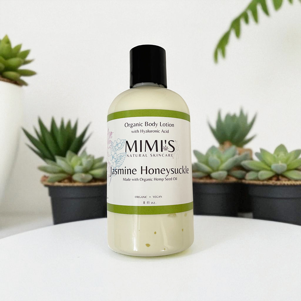 Bottle of MIMI's Jasmine Honeysuckle organic body lotion with plants in the background